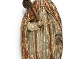 an old wooden statue of a man with a hat and a cane