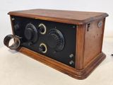 an old fashioned radio sitting on top of a table next to a cup