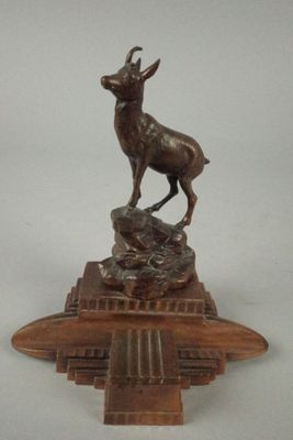 statue d'un cerf posée sur un socle avec une base en bois