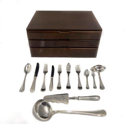 une boîte en bois sur laquelle est posé un service d'argenterie