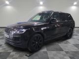Le Range Rover noir est garé sur un sol carrelé à damier.