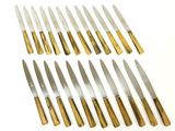 eight knives are lined up in a row on a white surface