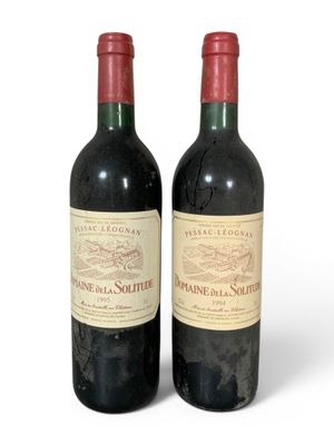 deux bouteilles de vin rouge posées l'une à côté de l'autre sur une surface blanche