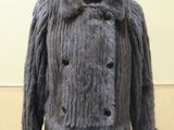 grey fur coat on a mannequin stand in a room