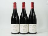 trois bouteilles de vin rouge sont alignées sur une surface blanche