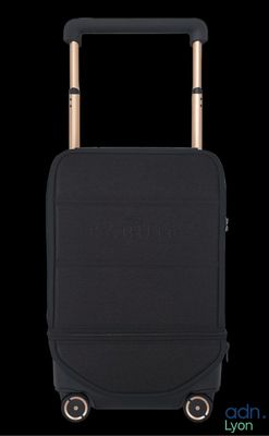 the black suitcase is sitting upright on the black surface