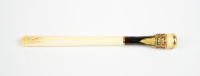 an old pipe with a wooden handle sitting on top of a white surface