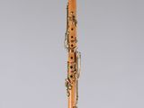 an orange and black clarinet on a clear surface