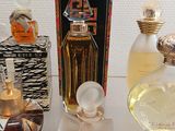 three bottles of perfume sitting on a shelf next to each other