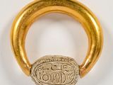 a close up of a gold ring with a scarrap on it