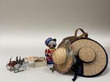 une petite figurine représentant un homme avec un chapeau de paille et un traîneau