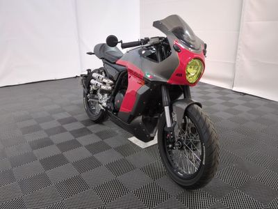 une photo d'une moto rouge et noire garée sur un sol à damier noir et blanc