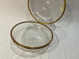 paire de bols en verre transparent aux bords dorés, posés sur un support blanc