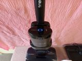 a vacuum that is sitting on a table next to a cell phone