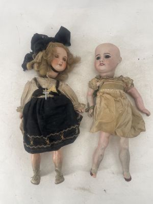 two dolls laying next to each other on a white surface