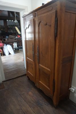 un grand meuble en bois dans le coin d'une pièce