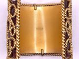 a gold belt with a chain around it on a white surface
