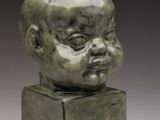 a bronze head of a baby on a square base