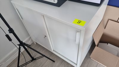 un micro-ondes posé sur un meuble, à côté d'une caméra