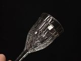 someone holding a wine glass in their hand against a black background