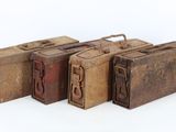 three old suitcases are lined up in a row on a white surface