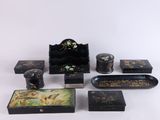 plusieurs meubles peints en noir et or posés sur une surface blanche