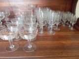 a lot of wine glasses sitting on a wooden table