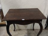 une petite table avec un plateau en bois sur un sol en béton