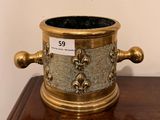 a brass vase on a wooden table with a price tag on it