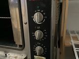 a small oven that is sitting inside of a kitchen