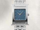 une montre en argent avec un cadran bleu, montée sur un bracelet en argent