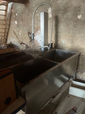 une photo d'une cuisine avec un évier et une échelle