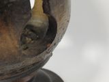 a close up of a metal vase with a hole in it