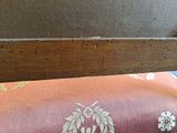 a close up of a bed with a wooden headboard