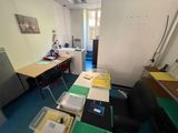 an image of a room with a desk, chair, and a refrigerator