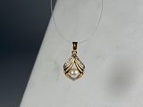 collier orné d'un pendentif en perle et diamants sur un fond blanc