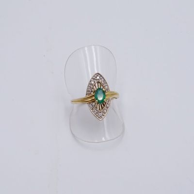 une image d'une bague en or avec une pierre verte au centre