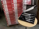 une boîte de couteaux posée sur une table à côté d'une pile de boîtes