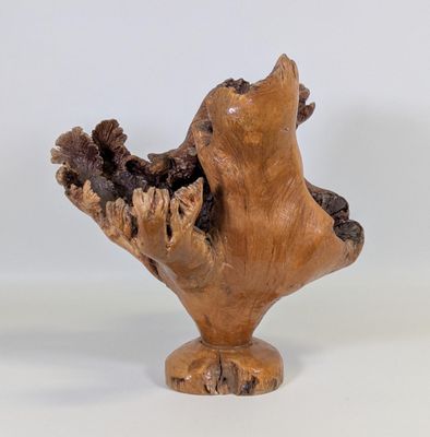 une petite sculpture en bois représentant un oiseau, posée sur un socle