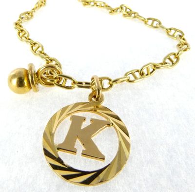 the initial k is inscribed in gold on a gold plated necklace