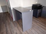 a desk with a printer on it in the corner of a room