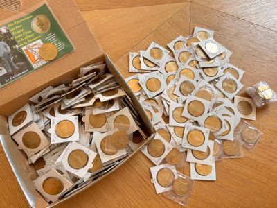 une boîte de pièces posée sur une table, à côté d'une boîte d'autocollants