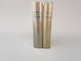 deux tubes de mascara posés sur une surface blanche, sur fond blanc