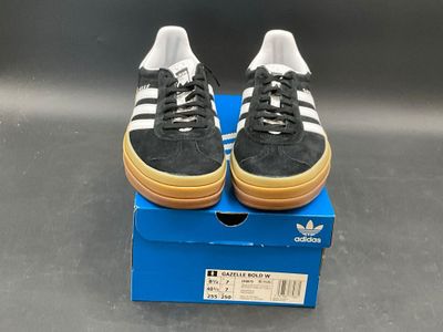 a pair of black and white shoes on a blue box