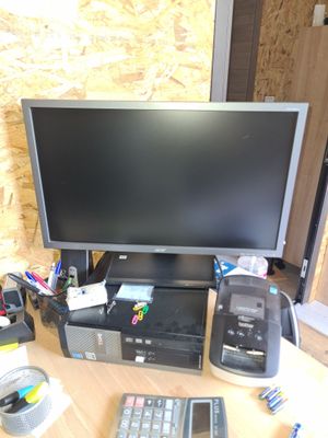 un bureau d'ordinateur sur lequel se trouvent un écran, un clavier, une souris et d'autres objets