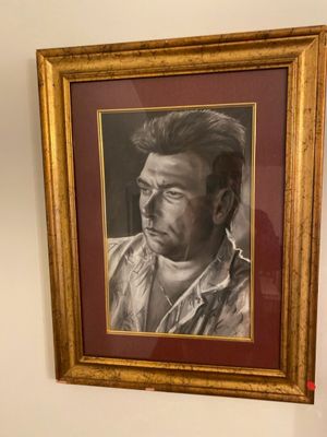 painting of a man in a cowboy shirt is hanging on a wall