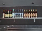 Des bouteilles d'alcool sont alignées sur une étagère dans un bar