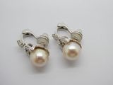 une paire de boucles d'oreilles en perles et en argent posées sur un fond blanc