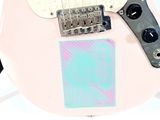 a pink electric guitar with a sticker on it