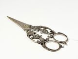 a pair of scissors sitting on top of a white surface